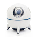 White spherical humidifier shaped like a spaceship with a blue trim & base, sitting on three feet. A small astronaut in a blue helmet is visible through a clear dome. Real image on white background.