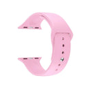 Soft pink silicone Apple Watch band with a smooth texture, featuring a silver pin-and-tuck closure and connecting lugs. Isolated on white. Real product photo.