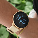 SmartWatch ZL02 Pro with round beige case & matte silicone strap on a wrist. Black display shows 10:25, WED JAN 03, 0 steps, 0 bpm. Real photo with blurred green foliage in background.