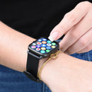 Black SmartWatch KT65 Pro with a silicone band on a wrist. A finger taps its sleek square touchscreen, showing colorful app icons & interactive functions. Worn next to a gold bracelet. Real image.