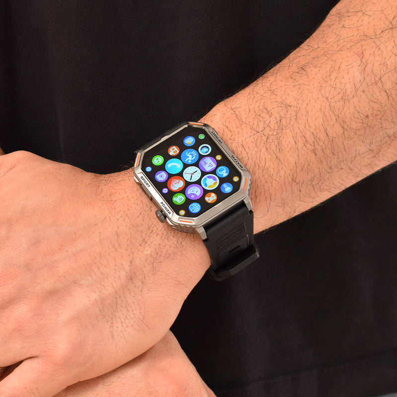 Rugged Reloj Inteligente G106 smartwatch on a male wrist. It has a silver/orange case, black textured strap, and a vibrant app icon screen. Features SPORT/POWER buttons & 'RESIST WATER' on bezel. Real photo, ideal for calls & sports.