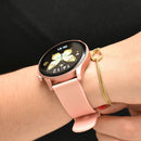 KC88 Smartwatch with rose gold casing & pink silicone band on a wrist. The round AMOLED display shows '14:12', '06-01', and a golden butterfly watch face. A gold bracelet is next to it. Real photo.