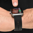 Smartwatch NX22 with a silver square case and black textured silicone strap on a wrist, a finger tapping the vibrant AMOLED screen showing fitness apps like "Actividad", "Entrenamiento", "Pasos". Real photo.