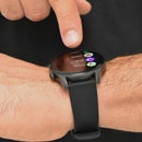 A real image showing a hand tapping a dark grey KC88 smartwatch with a black silicone strap on a wrist. The Amoled screen displays "Actividad," "Dormir," "Corazón" apps and features a round design.