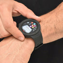 A black Smartwatch NX18 on a man's wrist. Its round screen displays 13:05, 08/04/Thu, an SOS icon, colorful app circles, and a small analog clock. The strap is black rubber. Real photo of the device.