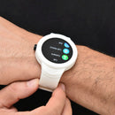 White Smartwatch NX18 on a man's wrist, featuring a round black screen showing 'Dial', 'Call History', 'Contacts', 'Call'. It has a white casing & ribbed silicone strap. Real photo.