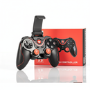 Black X3 wireless gamepad with red trim & textured grips, orange analog sticks, and a phone clip. Its red box, featuring "Qios" & "WIRELESS CONTROLLER", stands behind it on a reflective surface. Real product photo.