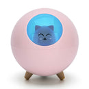 Pink spherical Planet Cat humidifier/night light, glossy plastic, featuring a blue dome showing a smiling black cat face silhouette, supported by three wooden legs. Real product photo.