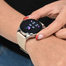 NX23 Pro Smartwatch on a woman's wrist. It has a round black screen displaying sleep tracking (moon icon, "00 h 00 m") with a faceted silver case and nude silicone strap. Her finger touches the display. Real image.