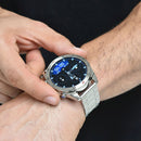 Polished silver smartwatch with a metal link bracelet on a man's wrist. The round digital screen shows blue time, date, and smart features against a dark background. Elegant, modern design with a metallic bezel. Real photo.