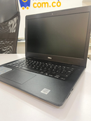 Used black Dell Vostro 3490 laptop open on a white desk. Shows keyboard, matte screen with DELL logo, and carbon fiber textured palm rest with Intel Core i5 sticker. Real product photo.