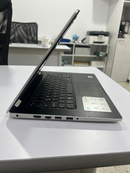 Used Dell Inspiron 3493 laptop, side view, partially open. Silver lid, black textured palm rest, white base. Visible HDMI, USB, audio ports, with Dell Inspiron sticker on palm rest. Real image on white desk.