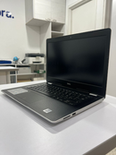 Used Dell Inspiron 3493 laptop, open on a white desk. Black display, keyboard & textured palm rest with Intel sticker. White chassis visible. DELL logo on screen bezel. Real photo in an office setting.