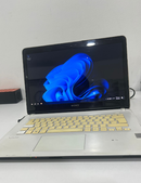 Used silver Sony VAIO laptop, open, showing Windows 11 blue wallpaper on its black screen. Features cream-yellow keys, visible VAIO & SONY logos, and a webcam. Real image.
