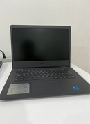 Used matte dark gray Dell Vostro 3490 laptop with black screen, keyboard, and trackpad visible. Features DELL, Intel Core, and feature branding stickers on the palm rest. Real photo on a white desk.